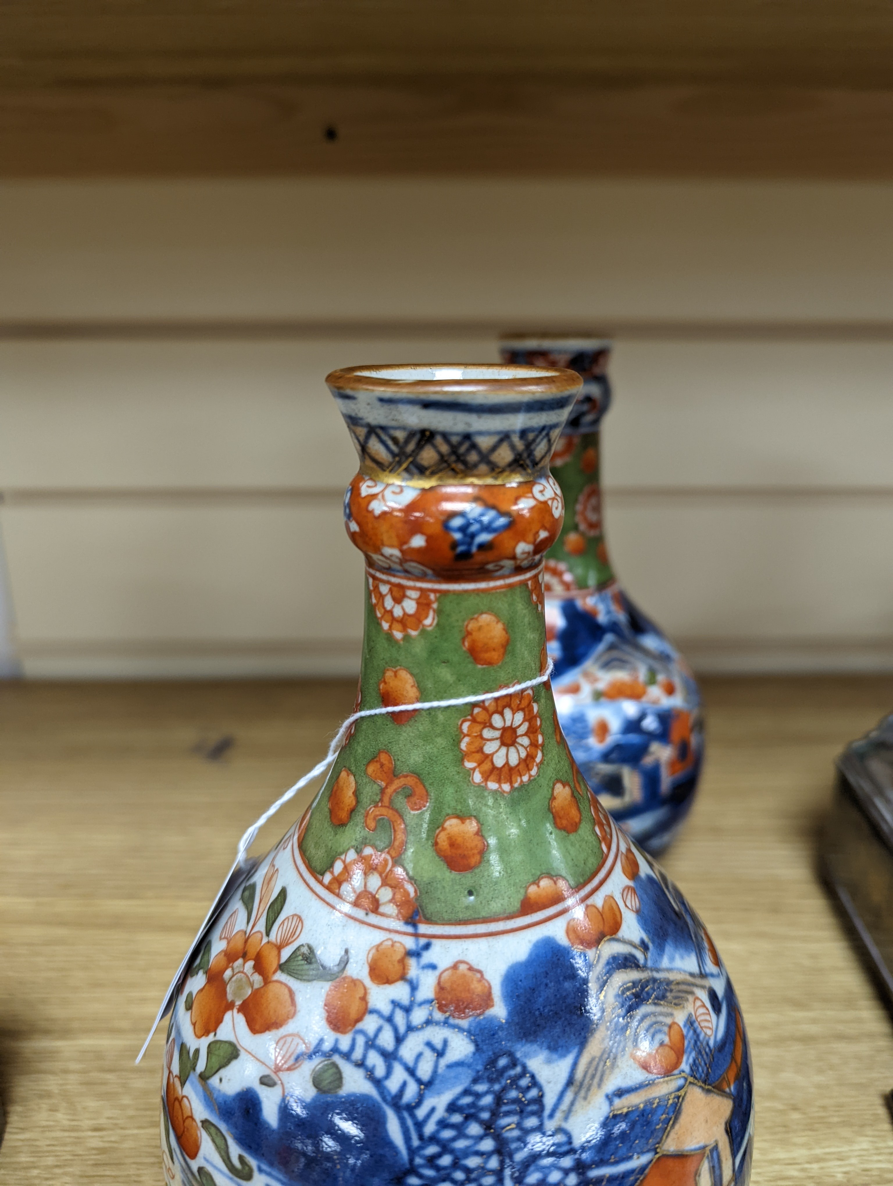 A pair of 18th century Chinese clobbered blue and white bottle vases 23cm